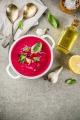 Vegan food, summer cold Beetroot gazpacho soup with lemon, avocado and fresh herbs copy space top view
