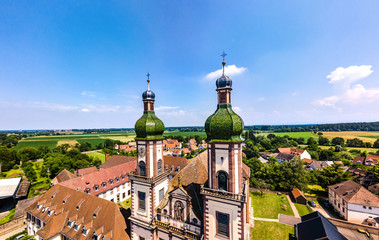 Obraz premium Soaring majestic church Saint Maurice in little french village Ebersmunster. Aerial drone view.