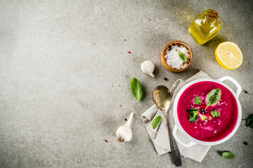 Vegan food, summer cold Beetroot gazpacho soup with lemon, avocado and fresh herbs copy space top view