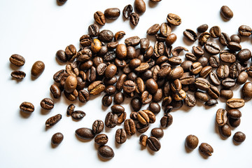 Fried coffee grains lie on a light surface on the table.