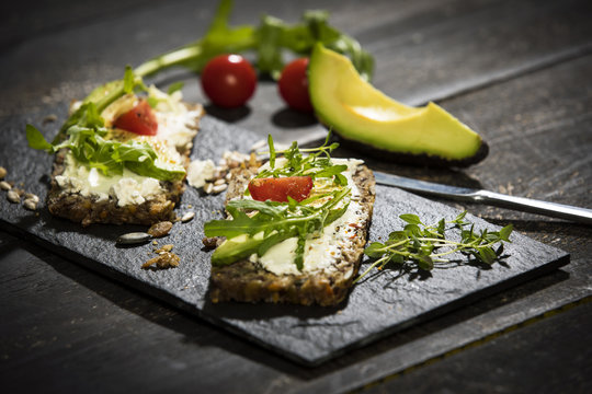 Onion bread with cream cheese, parma ham, avocado, rucola, thyme and tomato