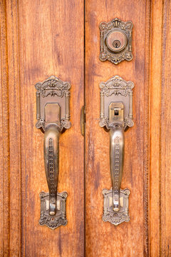 Vintage brass door handle with lock on wooden door