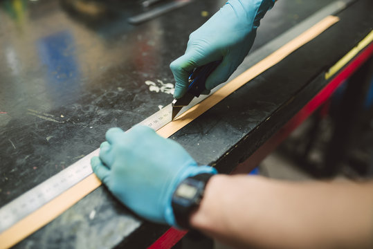 Close-up of man in workshop cutting wood with a cutter