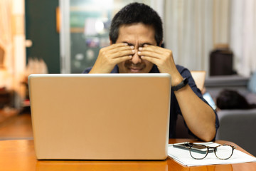 Businessman feeling strain in his eyes after working long hours on computer