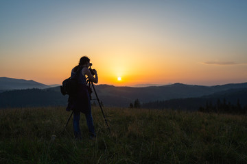 Photographer shoots landscape at sunset