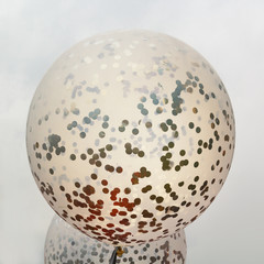 Balloons against the gray sky in backlight. Abstract background. Square