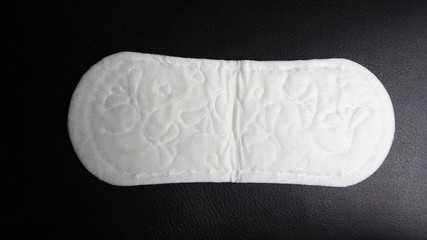 Sanitary pad isolated on black back ground top view.
