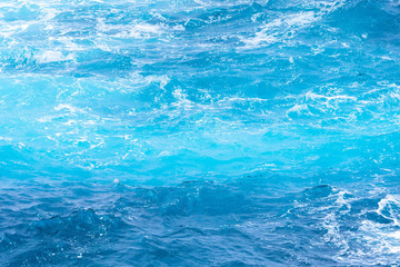 Atlantic ocean with blue water on a sunny day. Waves, foam and wake caused by cruise ship in the sea