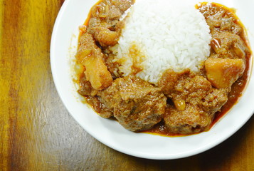pork curry and potato with rice on plate
