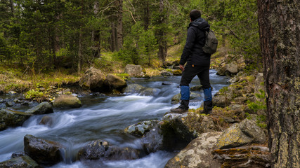 Obraz premium camper who strolls by the river running through the forest