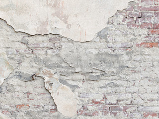 Peeling wall with a red brick under the plaster. Vintage background