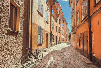 Bicycle abandoned on narrow colorful street with old houses of Gamla Stan (Old Town) in Sockholm, Sweden.