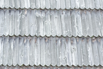 Old roof is made of wooden tiles. Texture. Close-up