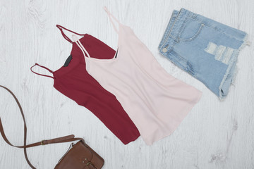 Pink and burgundy tank top, ripped jeans shorts. Fashionable concept