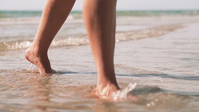 Woman legs coming out of the sea, vacation concept. Slow motion.