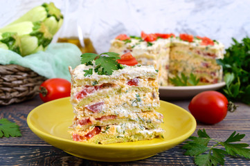 A piece of delicious cake of zucchini, tomatoes and cheese on a wooden table. Vegetable cake.