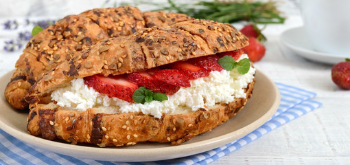 Cereal croissants with cream cheese and fresh strawberries. Useful breakfast. Proper nutrition. French traditional dishes.