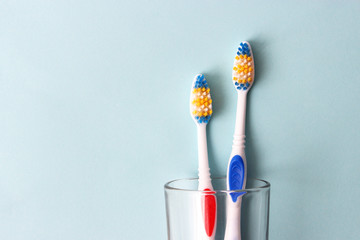 toothbrushes in a glass on a colored background. oral health, brush your teeth, healthy teeth - obrazy, fototapety, plakaty