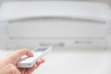 エアコンのリモコンを操作する手