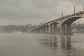 Fototapeta na wymiar Bridge in the fog over the river