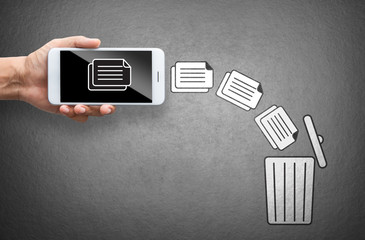 business hand throw data file from mobile to trash bin