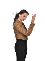 portrait of brunette girl wearing brown leather jacket.   white studio background