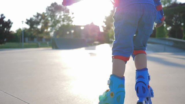 active leisure, small boy riding on rollers at Skate Park in bright sunlight close-up on vacation