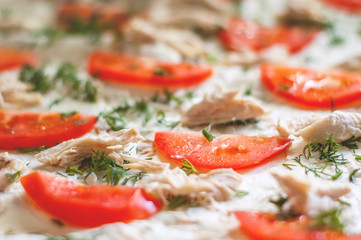 Pizza ingredients are closeup. Tomatoes, chicken, cheese, dill. Blurred background