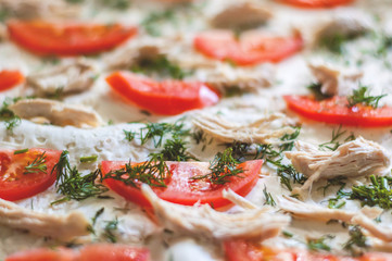 Pizza ingredients are closeup. Tomatoes, chicken, cheese, dill. Blurred background