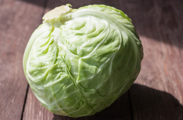 Early cabbage, white cabbage head on wooden background