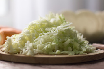 white cabbage cut into strips and carrots on a wooden Board for cooking