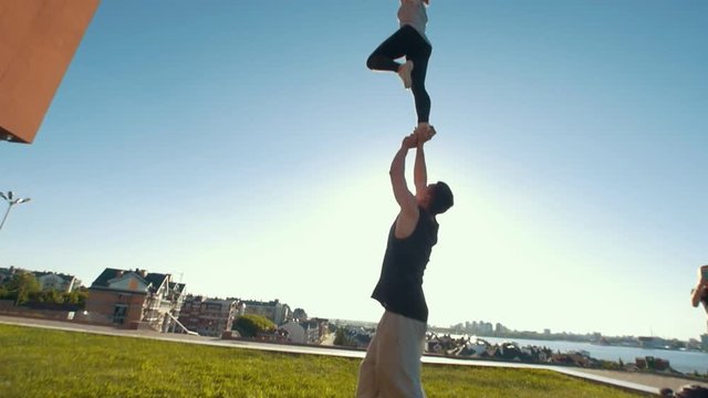 Young teenagers practice cheerleading at background girl shooting on phone outdoors in summer day