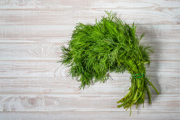 green dill on white wooden background