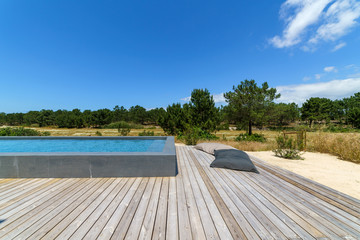 Modern house with garden swimming pool and wooden deck