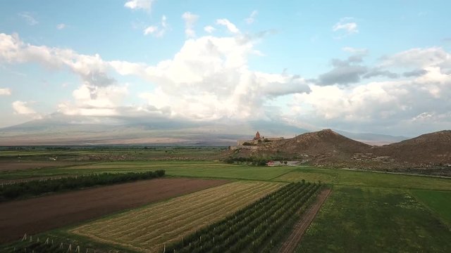 Aerial view of 17th century monastery Khor Virap from a drone flying over agricultural field on the border of Armenia next to Mt Ararat. Ararat Province, Armenia.