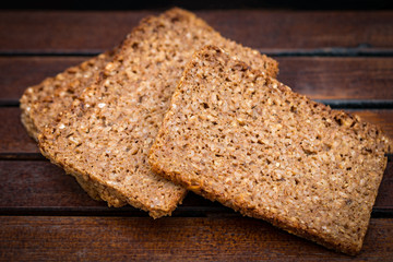 Fresh baked bread or bun with sesame on wood background