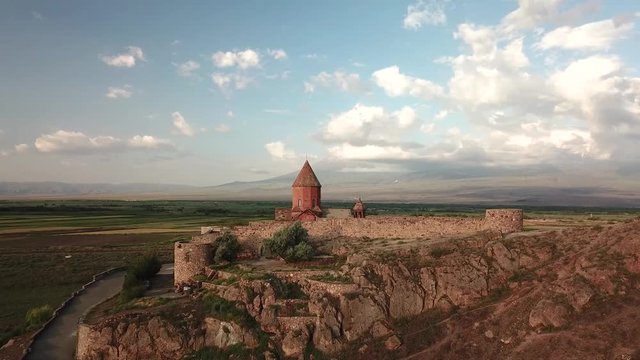 Aerial view of 17th century monastery Khor Virap from a drone flying over agricultural field on the border of Armenia next to Mt Ararat. Ararat Province, Armenia.