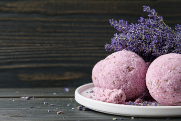 Lavender bath bombs and beautiful lavender flowers on dark wooden table. Natural skincare cosmetics