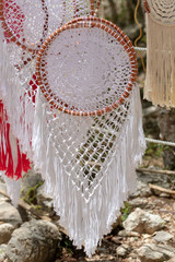 Fototapeta na wymiar A delicate, charming, white dream catcher at the stand with Mexican hand-made souvenirs