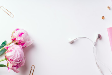 Feminine workspace with pink peons on white background with copy space