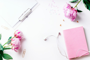 Feminine workspace with pink peons on white background with copy space