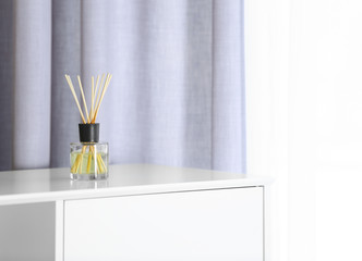 Aromatic reed air freshener on chest of drawers at home