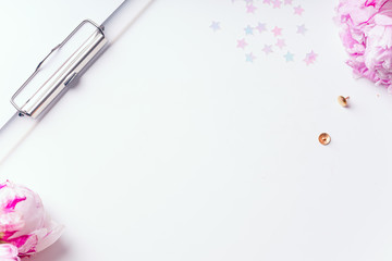 Feminine workspace with pink peons on white background with copy space