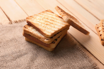 Tasty toasted bread on wooden table