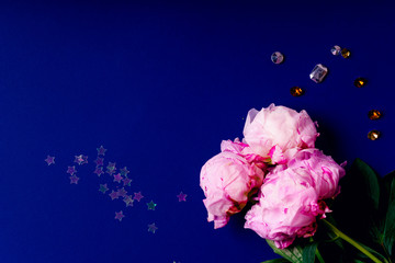 Flat lay composition with peons on blue background. Top view, copy space