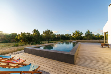 Modern house with garden swimming pool and wooden deck