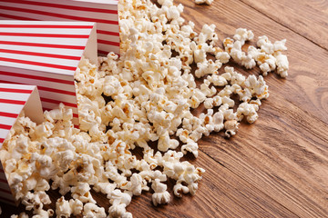 Bucket of popcorn on wooden background