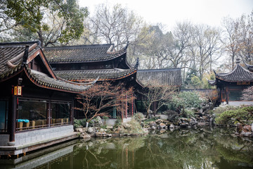 traditional chinese architecture and tea house reflecting on a pond with red carps (translation:...