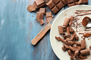 Plate with delicious chocolate curls on table