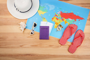 Composition with tourist's stuff with map on wooden background, top view